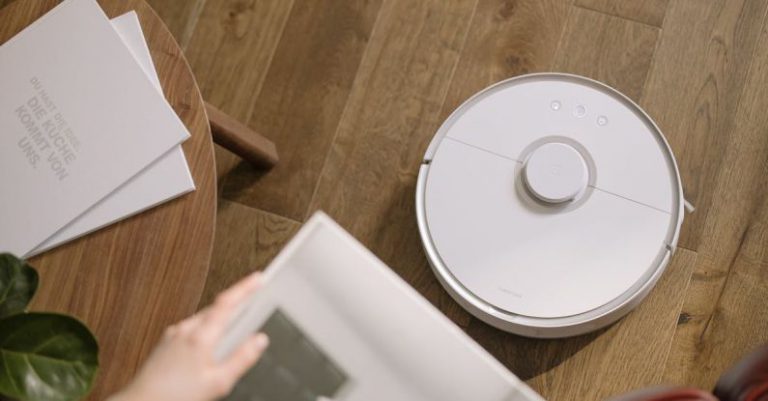 Robotic Vacuum - Person Holding White Round Device