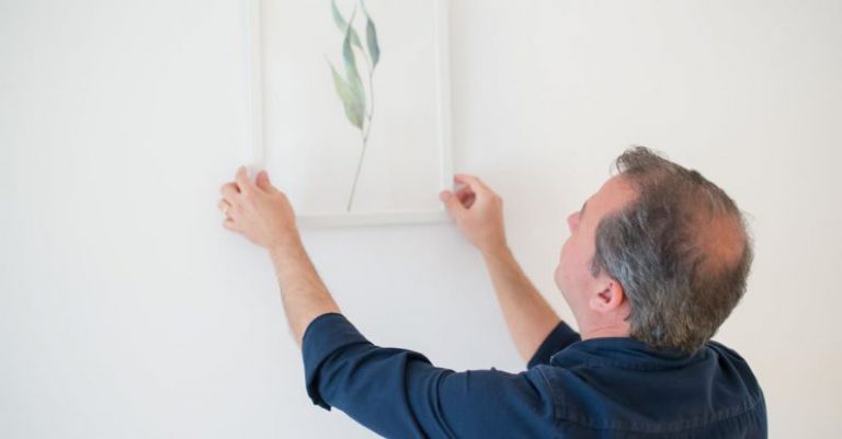 Wall Removal - Man in Blue Long Sleeve Shirt Holding White Frame on the Wall