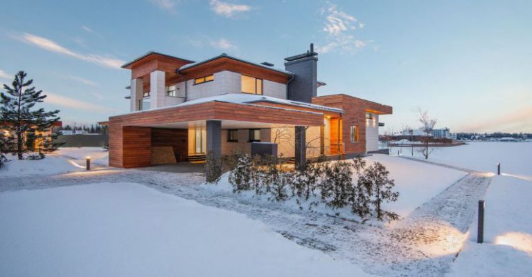 New Roof - Exterior view of luxurious residential house with roofed parking and spacious backyard in snowy winter countryside