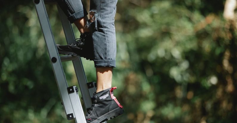 Ladder Safety - Faceless camper climbing ladder in forest