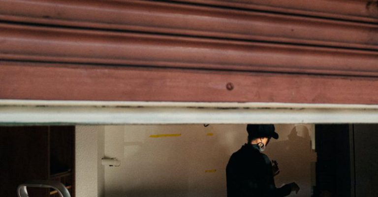 Smart Garage - Man in Black Jacket Standing Near Red Wall