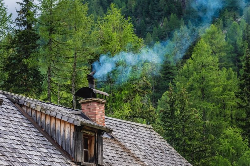 Chimney - brown wooden house near green trees during daytime